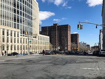 Wide City Street Intersection with Tall Buildings and Blue Sky