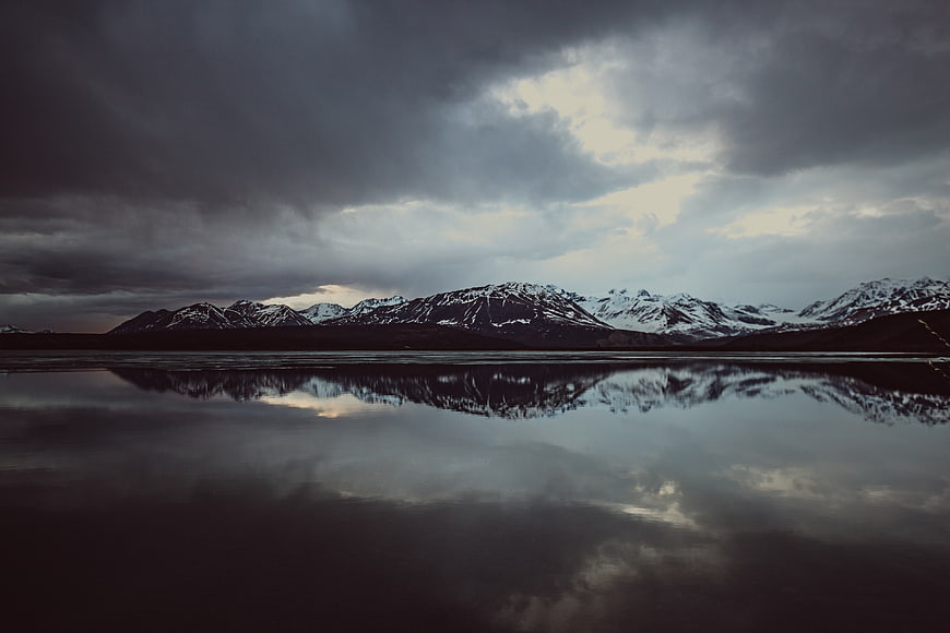 Dramatic Snow-Capped Mountains Reflected in Calm Lake