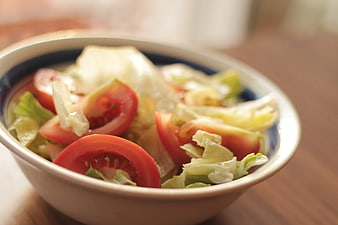 Fresh tomato and lettuce salad in a ceramic bowl