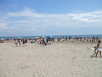 Crowded Beach Scene with People Relaxing on Sand