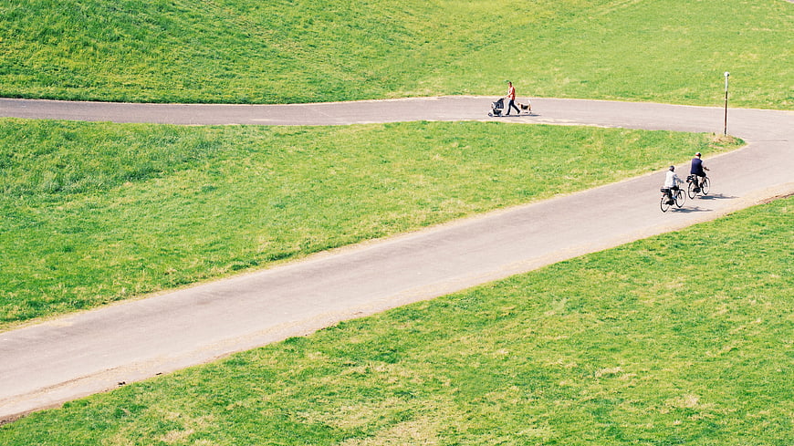 High angle view of cyclists and pedestrian on winding park path