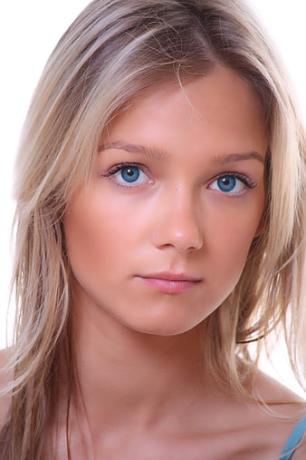 Close-up portrait of a young blonde woman with striking blue eyes