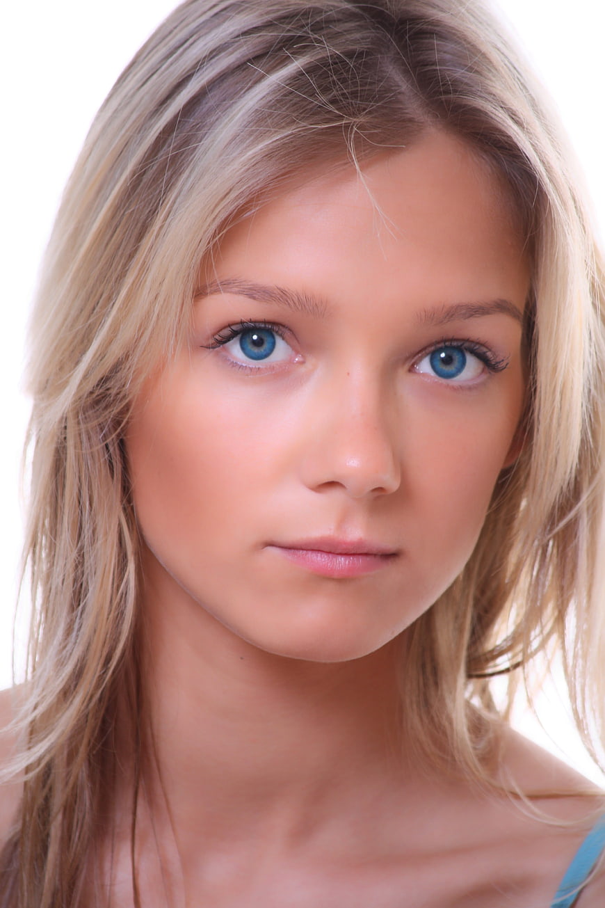 Close-up portrait of a young blonde woman with striking blue eyes