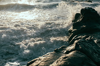 Dramatic Ocean Waves Crashing Against Dark Rocky Coastline