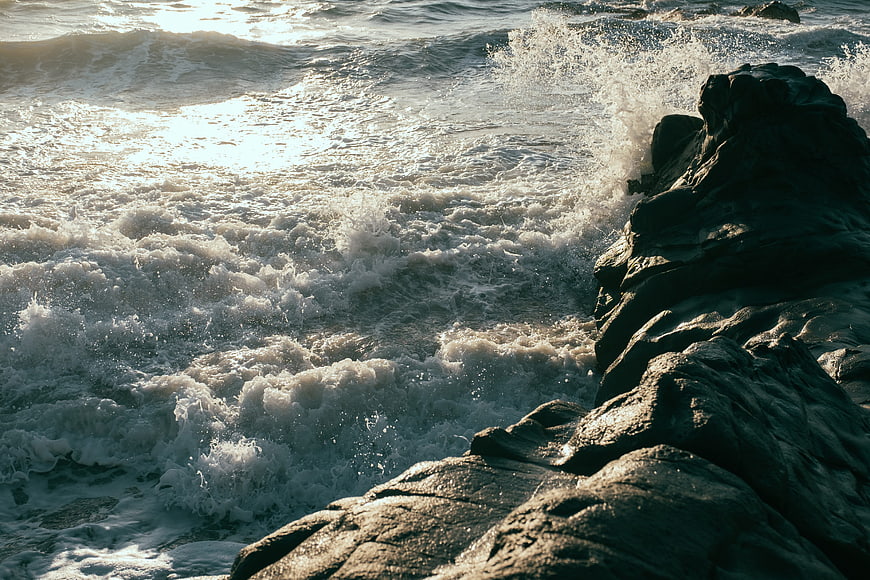 Dramatic Ocean Waves Crashing Against Dark Rocky Coastline