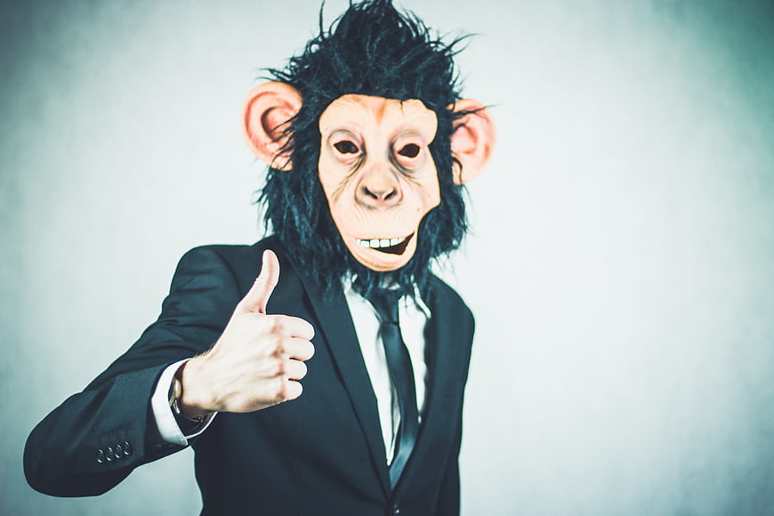 Man in Monkey Mask Giving Thumbs Up in Business Suit