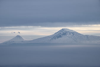Snow-capped mountains rising above a sea of clouds