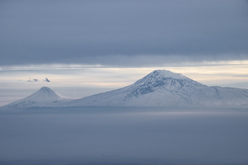 Snow-capped mountains rising above a sea of clouds