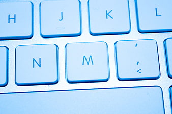Close-up of white computer keyboard keys with blue lighting