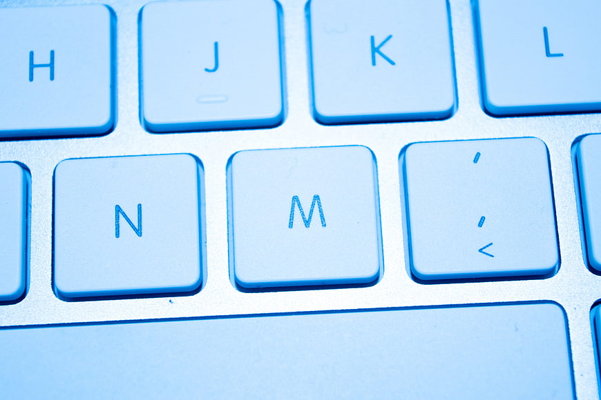 Close-up of white computer keyboard keys with blue lighting