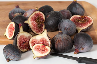Fresh ripe purple figs on wooden cutting board