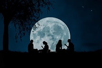 Silhouetted friends sitting on a hill under a giant full moon at night