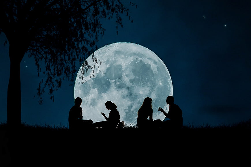 Silhouetted friends sitting on a hill under a giant full moon at night