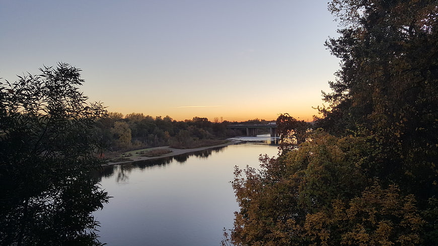 Serene River Landscape at Sunset with Autumn Trees