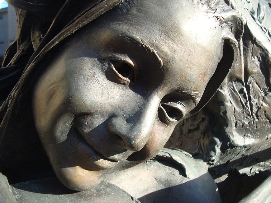 Close-up of bronze female statue face with serene expression