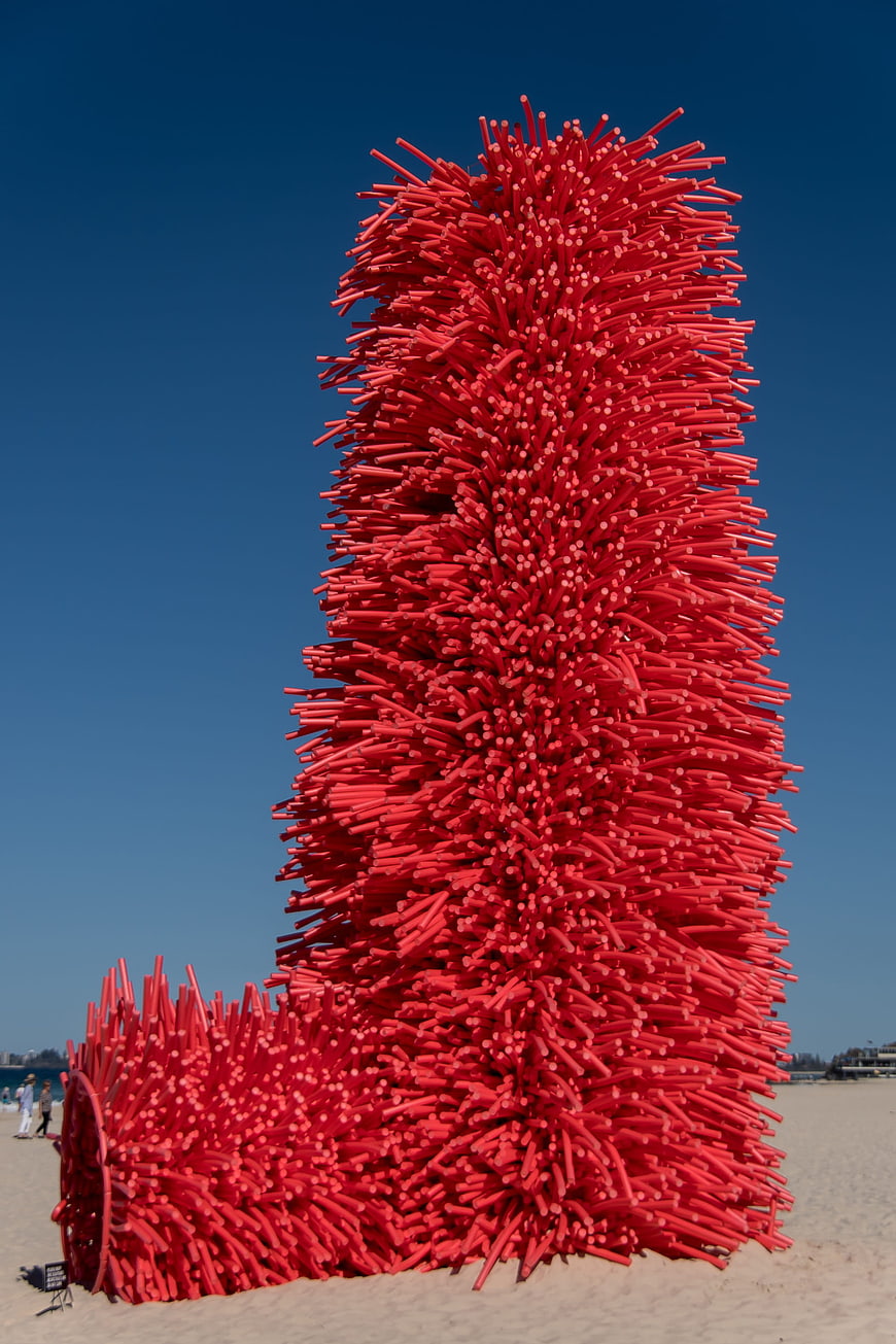 Giant red foam sculpture on sandy beach
