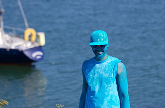 Man Covered in Blue Powder by the Water