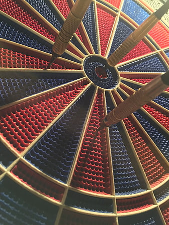 Close-up of red and blue dartboard with three darts