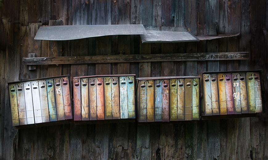 Rusty vintage mailboxes on weathered wooden wall