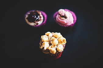 Overhead view of gourmet cupcakes with popcorn and berry toppings