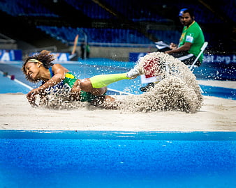 Female Athlete Landing in Long Jump Sand Pit