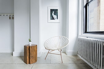 Modern white interior with Acapulco chair and wooden side table