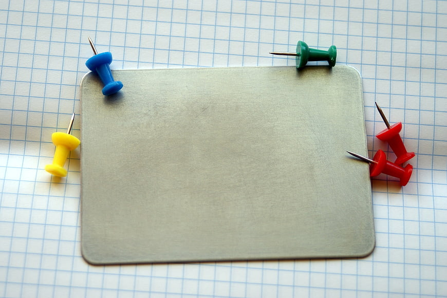 Blank Metal Plate with Push Pins on Grid Paper