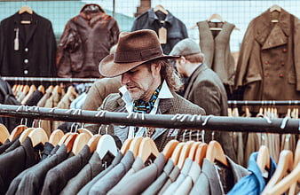 Man in Fedora Browsing Vintage Clothing Racks