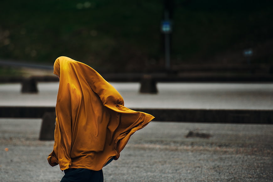 Person in yellow raincoat walking in the rain