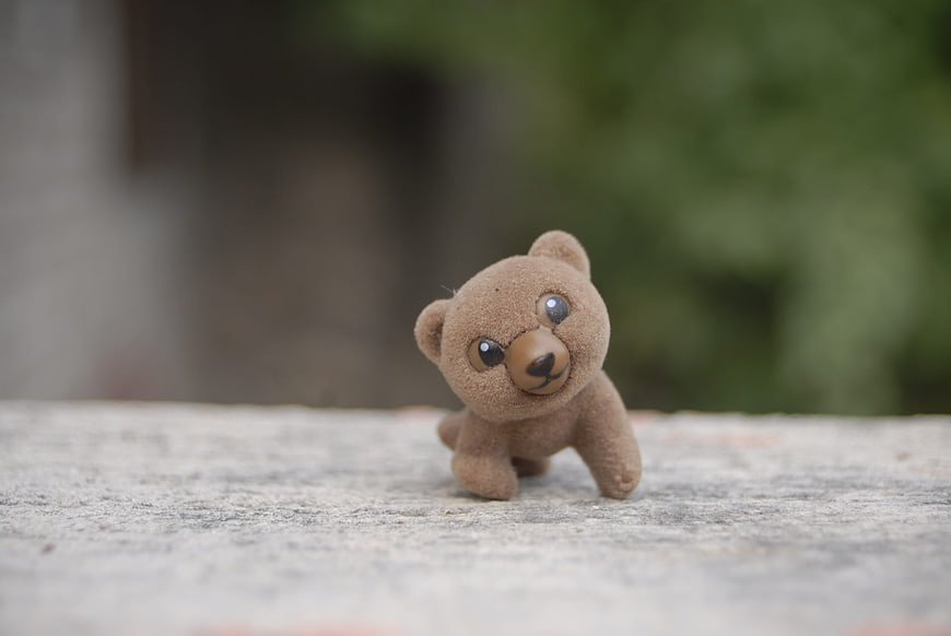Cute Miniature Brown Teddy Bear Toy on Stone Surface