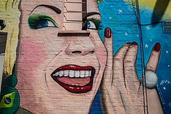 Colorful Street Art Mural of Smiling Woman on Brick Wall