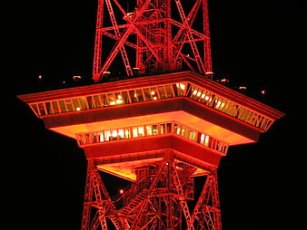 Red illuminated Eiffel Tower observation deck at night