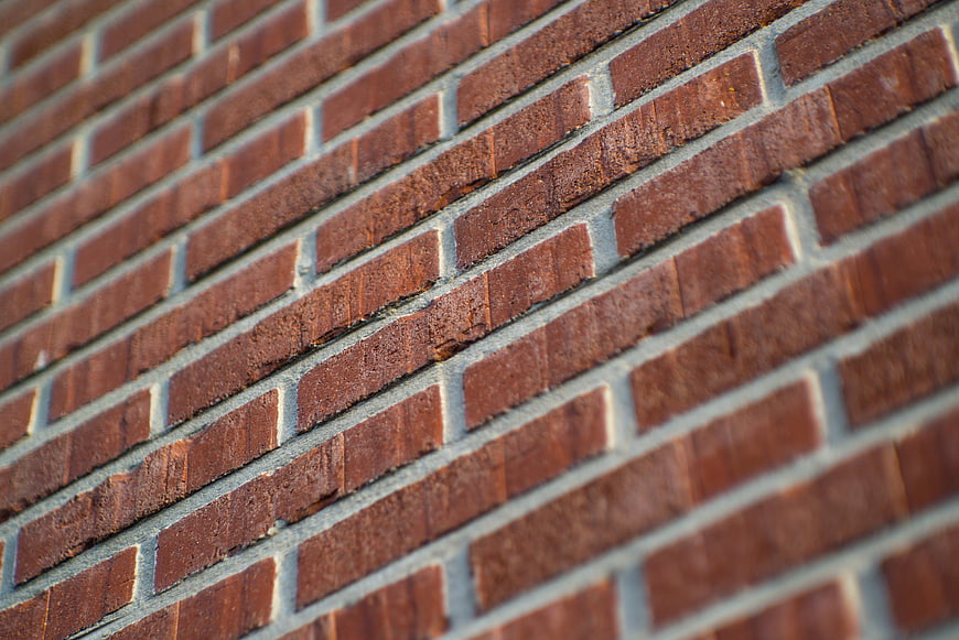 Close-up of red brick wall texture with gray mortar