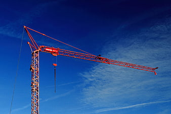 Red Construction Crane Against Blue Sky