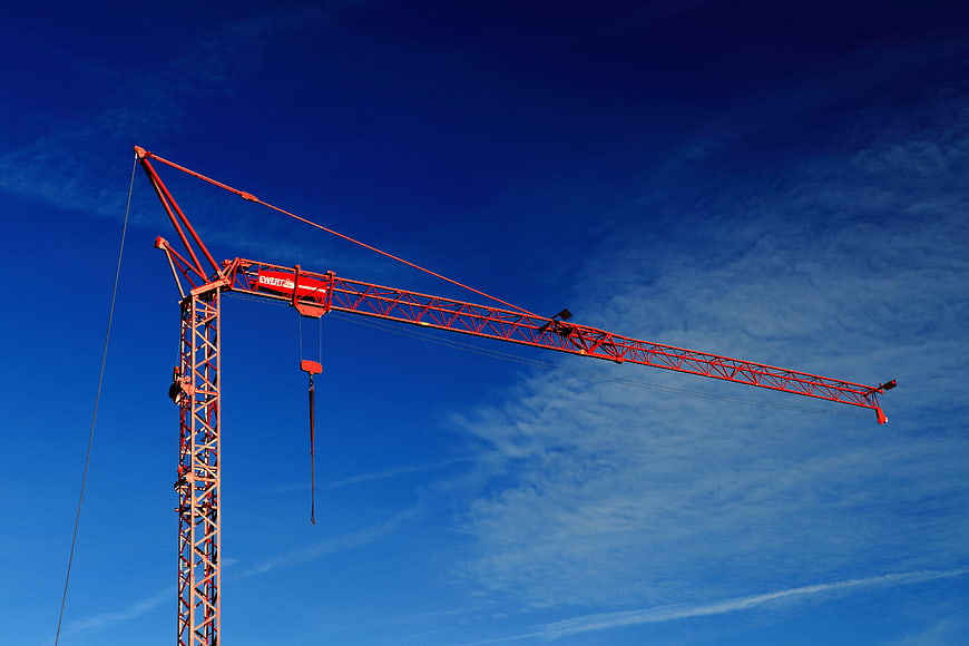 Red Construction Crane Against Blue Sky