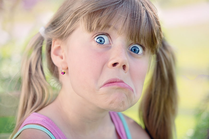 Close-up portrait of young girl making funny face