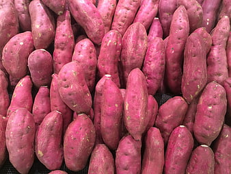 Pile of fresh red sweet potatoes on black mesh