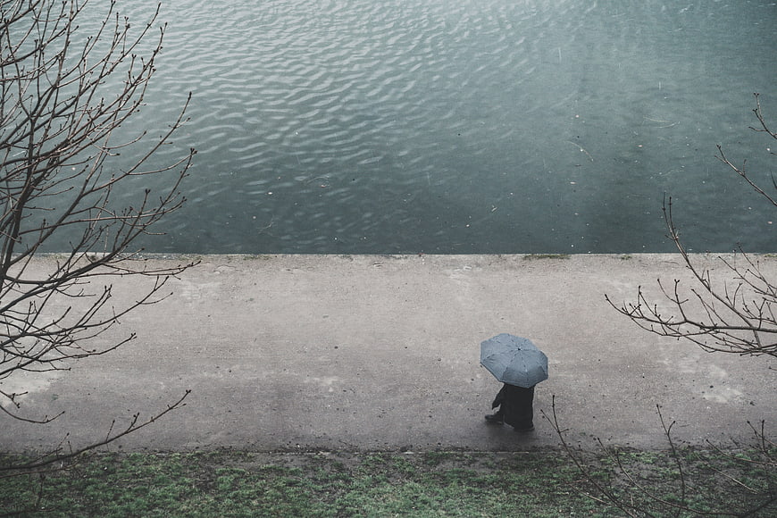 High angle view of person walking with umbrella by river