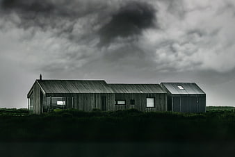 Modern wooden house under dramatic stormy sky