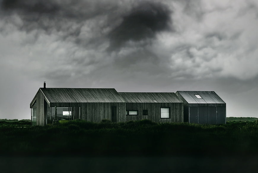 Modern wooden house under dramatic stormy sky