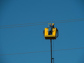 Electrician Working On High Voltage Power Lines In Aerial Lift