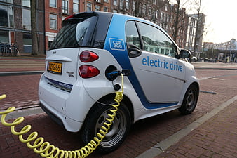 White Smart Electric Car Charging on City Street