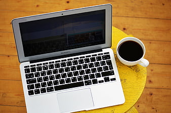 MacBook Air with Arabic Keyboard and Coffee on Yellow Stool