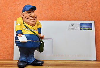 German Postman Figurine with Envelope on Wooden Surface