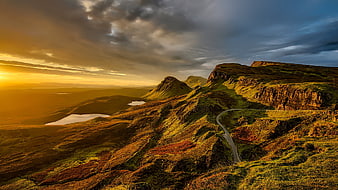 Dramatic Sunset Over Winding Mountain Road in Scottish Highlands