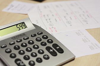 Calculator and Financial Documents on Wooden Desk