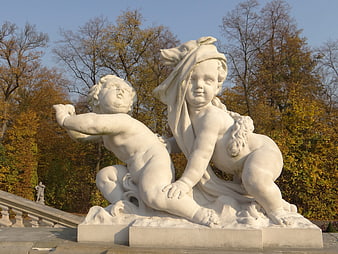 White Marble Putto Sculpture in Autumn Park