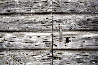 Weathered wooden door with rustic metal latch and keyhole