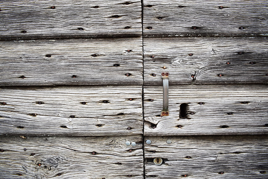 Weathered wooden door with rustic metal latch and keyhole
