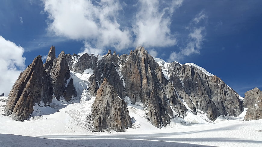 Majestic jagged mountain peaks covered in snow under blue sky